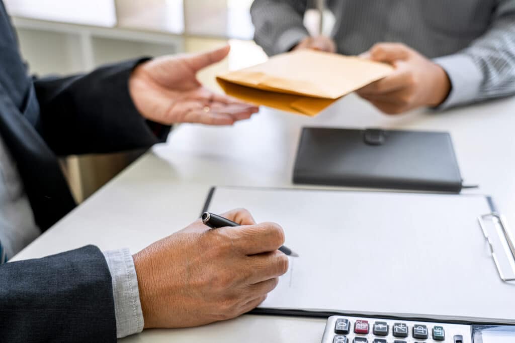 selling a home in North Georgia: Bribery and corruption concept, bribe in the form of dollar bills, consultant receive money from businessman while making deal to agreement a real estate corporate contract and financial.