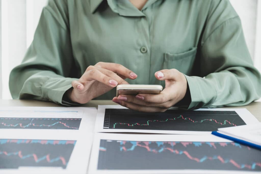 selling a home in North Georgia: Trader businesswoman analyze stock graph and report, set targets for online forex trading market management success.