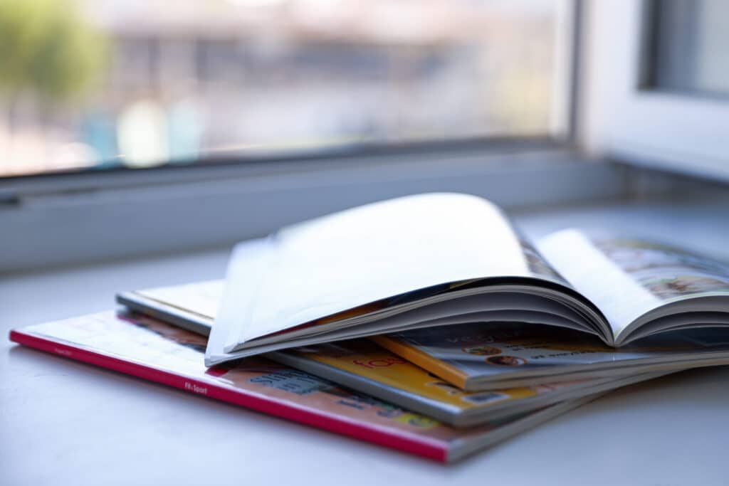 selling a home in North Georgia: Group of magazines on windowsill indoors, closeup
